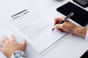 A small business owner signing paperwork in a workspace