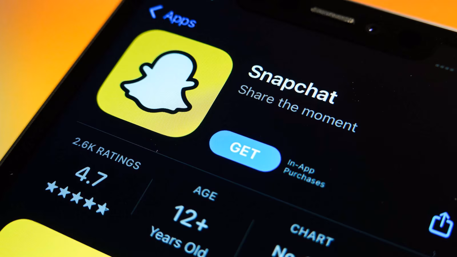 Smartphone showing Snapchat app listing in a mobile app store with 12-plus age rating.
