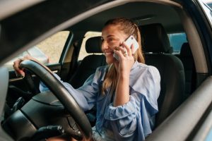 an image of a person driving a car while looking at their cell phone