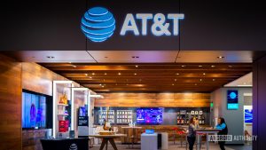 Interior of an AT&T retail store with the illuminated AT&T logo above the entrance and customers seated inside, symbolizing the company&rsquo;s brand amid the 2025 data breach settlement news.