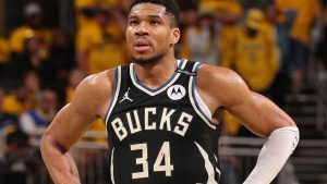 Giannis Antetokounmpo standing on the court in a Milwaukee Bucks uniform during a game.
