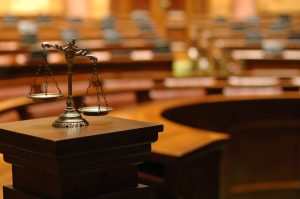 Scales of justice on a podium in an empty courtroom, symbolizing legal balance and judicial authority.