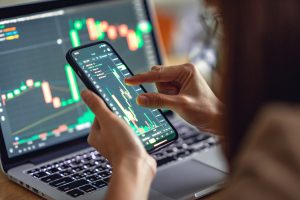 woman is checking bitcoin price chart on digital exchange on smartphone, cryptocurrency future price action prediction.
