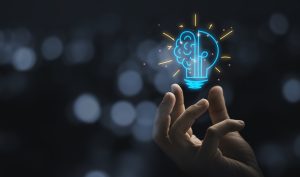 hand holding drawing virtual lightbulb with brain on bokeh background for creative and smart thinking idea concep