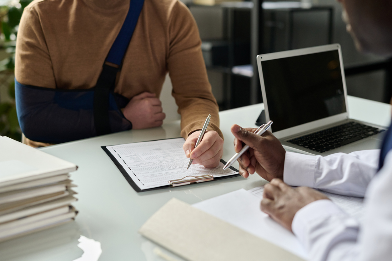 close up of man filling in medical insurance form