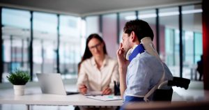 Injured man wearing a neck brace discusses his personal injury case with a California lawyer.