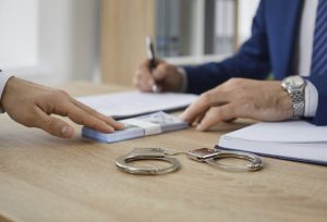 man gives some money to a bondsman asking to release someone from prison on bail