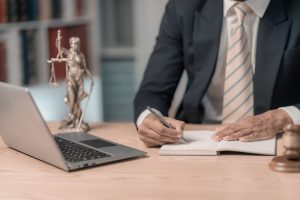 lawyers working with documents law, advice and justice concept, lawyer in suit signing legal document at table with justice scale, close up