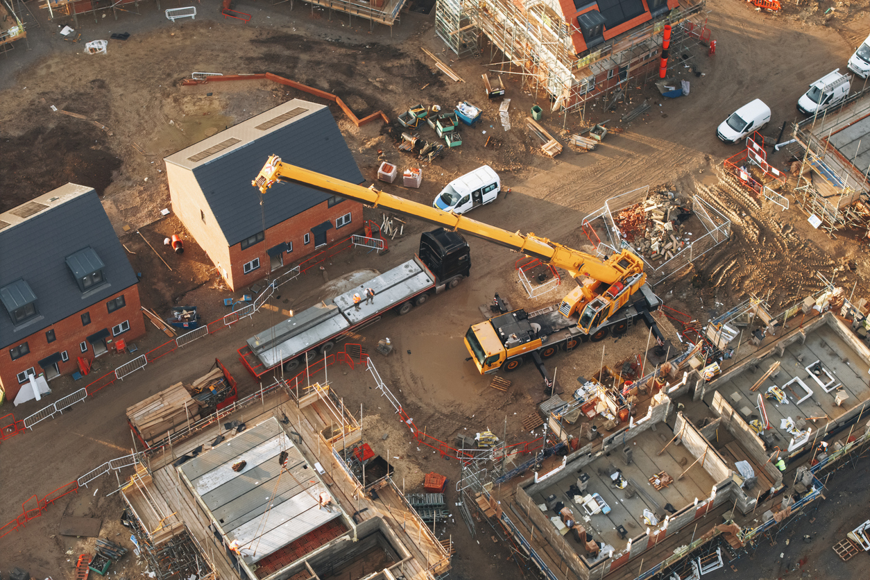 aerial view of yellow mobile crane at construction site performing lifting operation