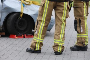 firefighters standing around a car