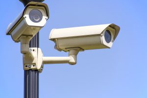 Surveillance cameras monitoring a public space, symbolizing how digital records and metadata continue to track reputational and regulatory risk after a presidential pardon.